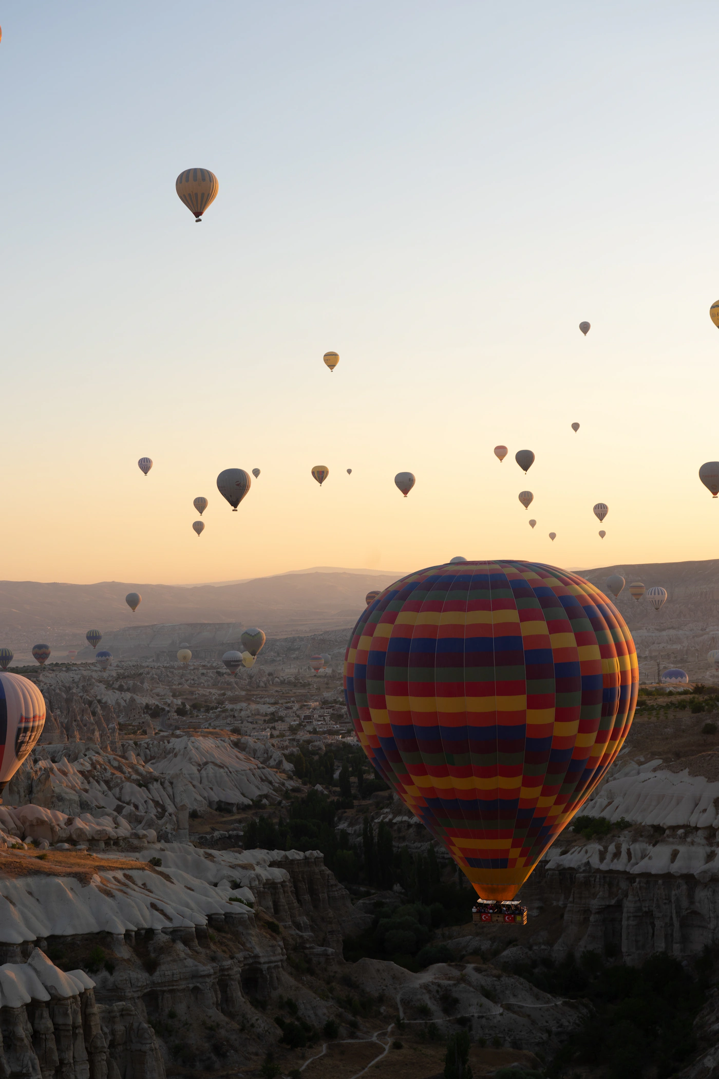 Adventure hot air balloons floating above Cappadocia at golden sunrise