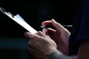 A close-up of hands writing on a notepad during a training session.