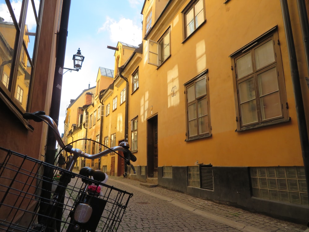 a bicycle parked next to a yellow building