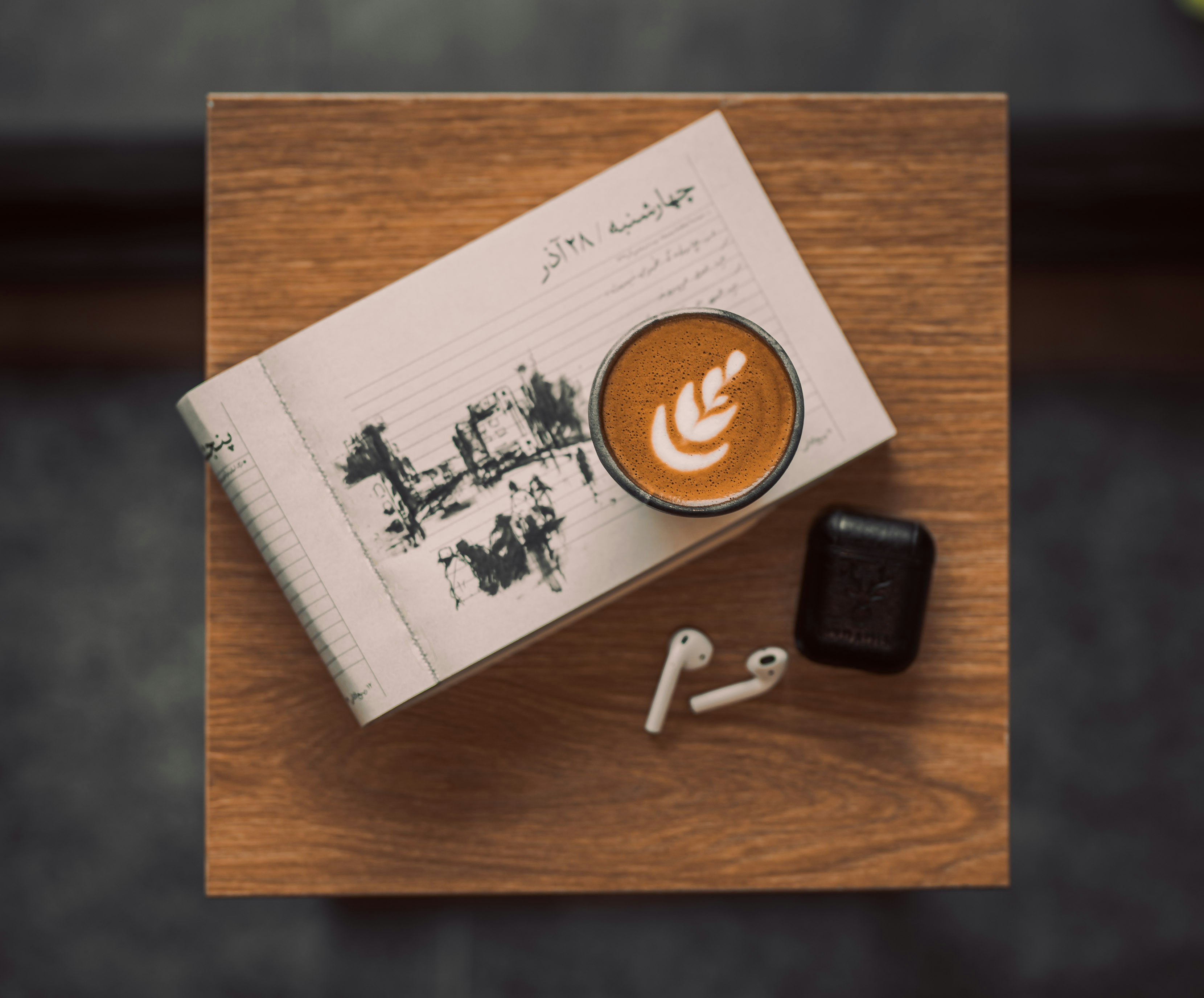 a cup of coffee sitting on top of a wooden table