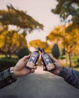 Hands holding a brewviva coffee pack with tropical leaves blurred in the background.