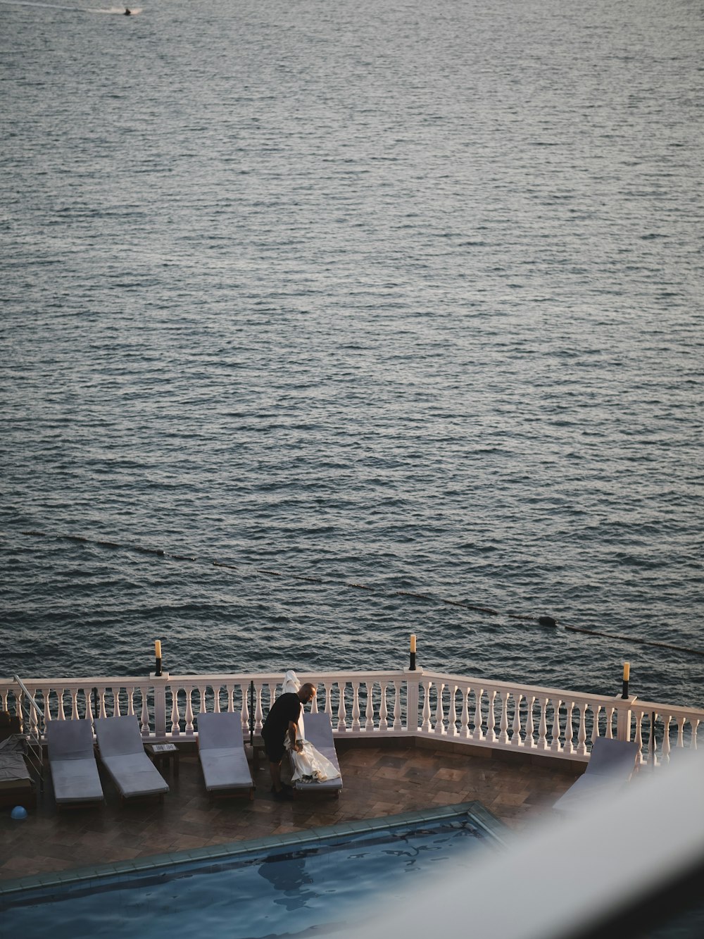 a man sitting on a bench next to a body of water