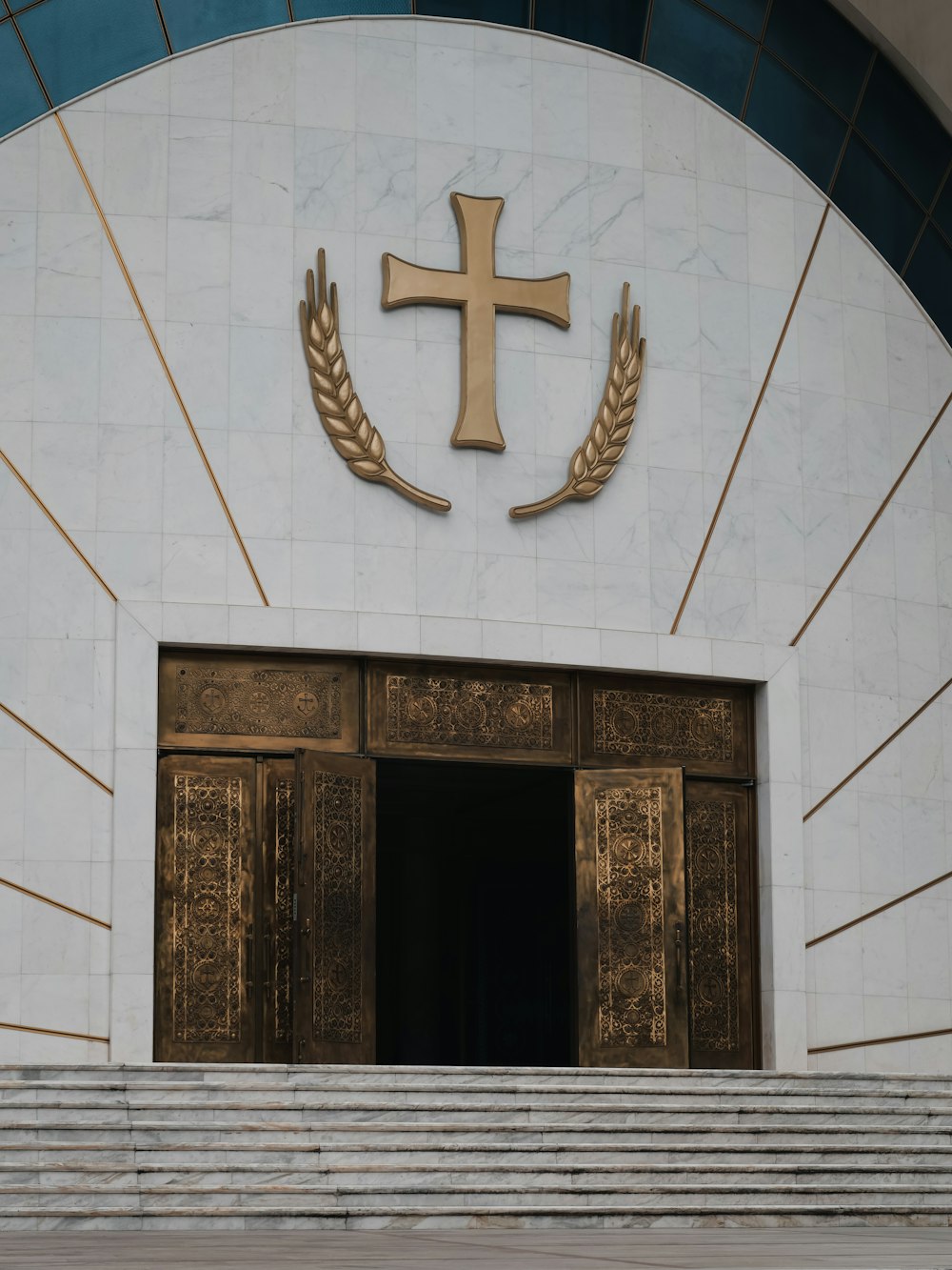 a church entrance with a cross above the door