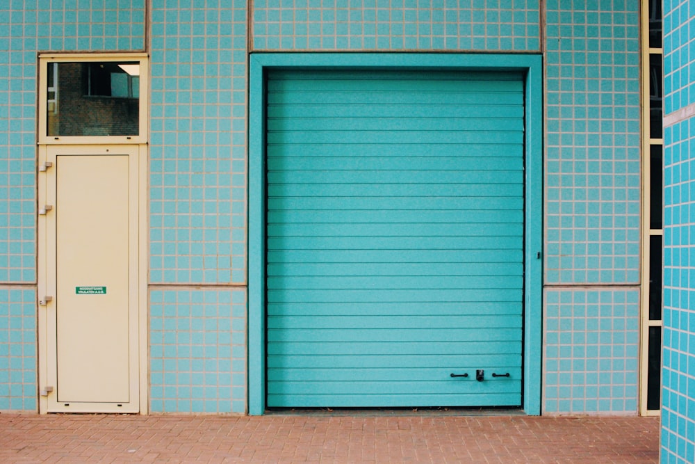 a blue building with a white door and a brick sidewalk