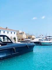 a blue boat in the water next to a white building