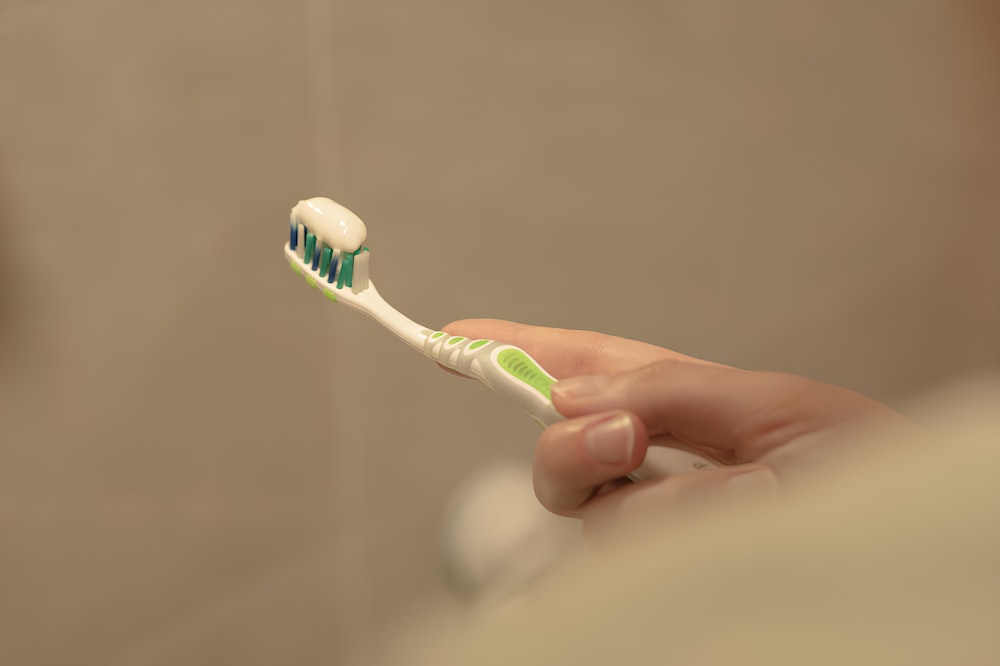 a close up of a person holding a toothbrush