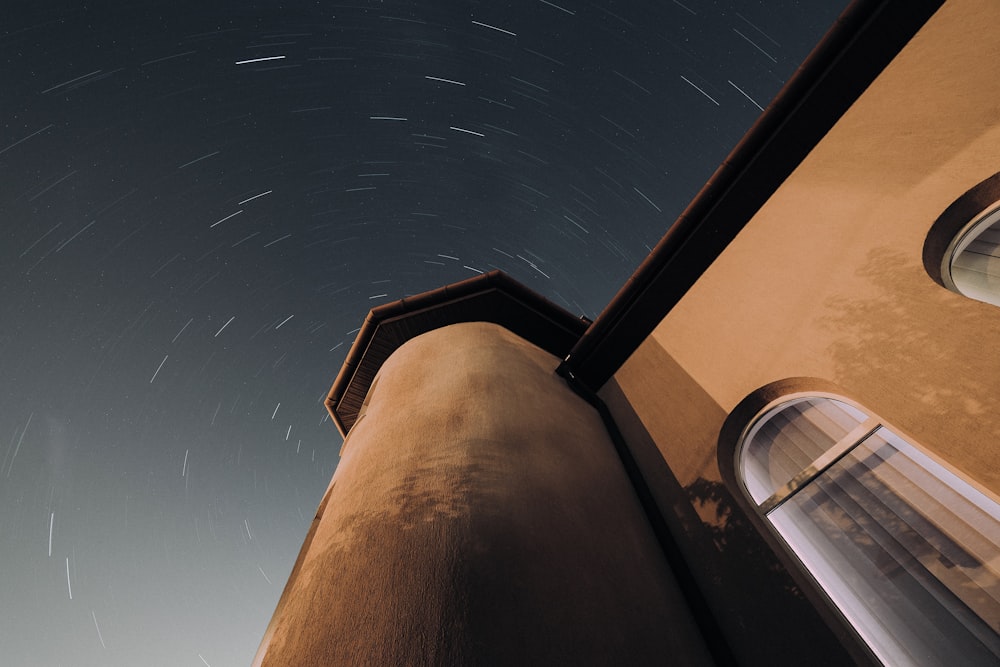 a tall building with a star trail in the sky