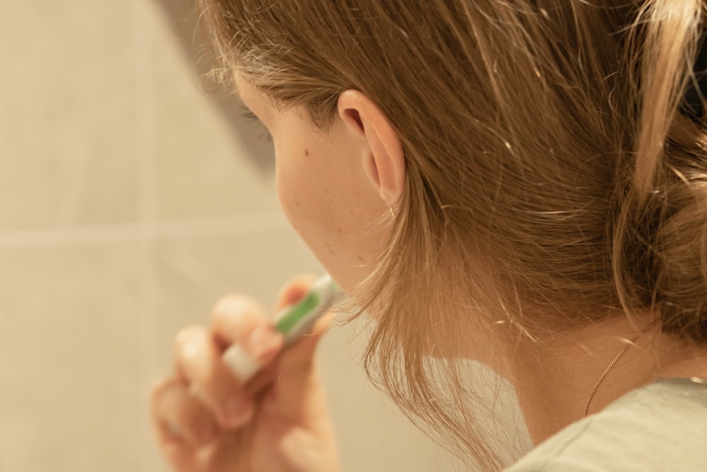 a woman brushing her teeth in front of a mirror