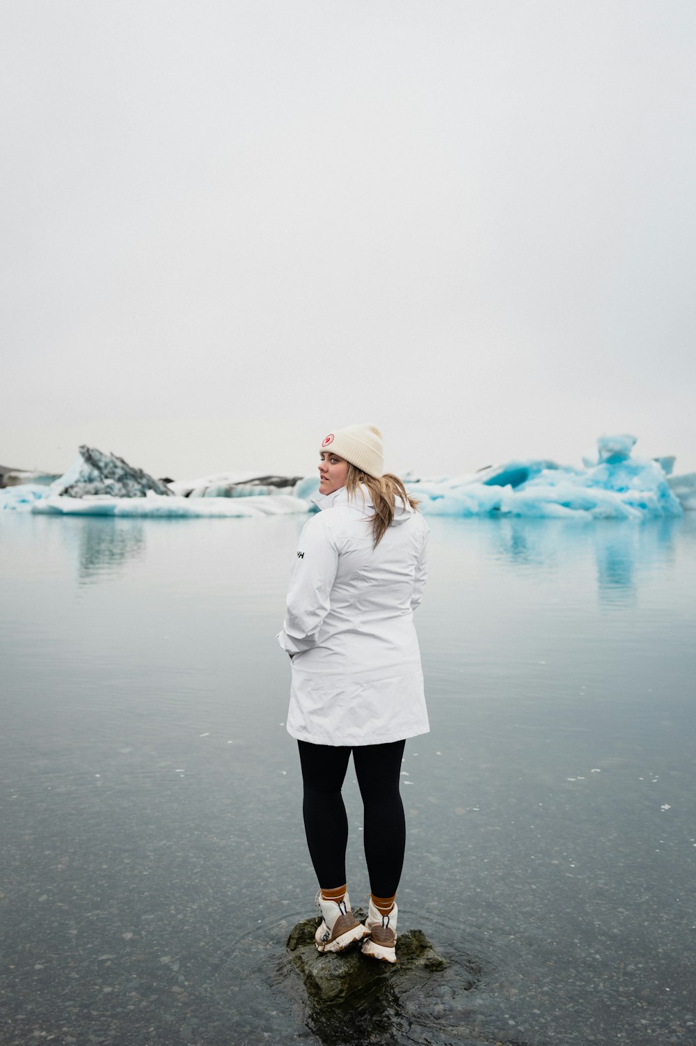 a woman standing on a rock in the water