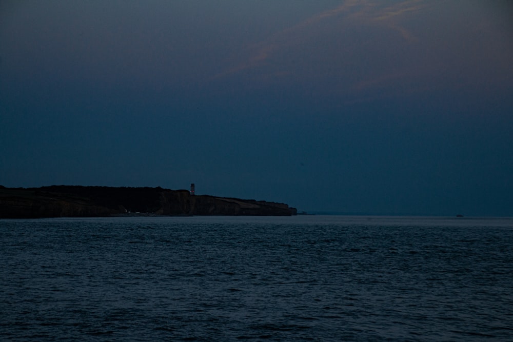 a large body of water with a lighthouse in the distance