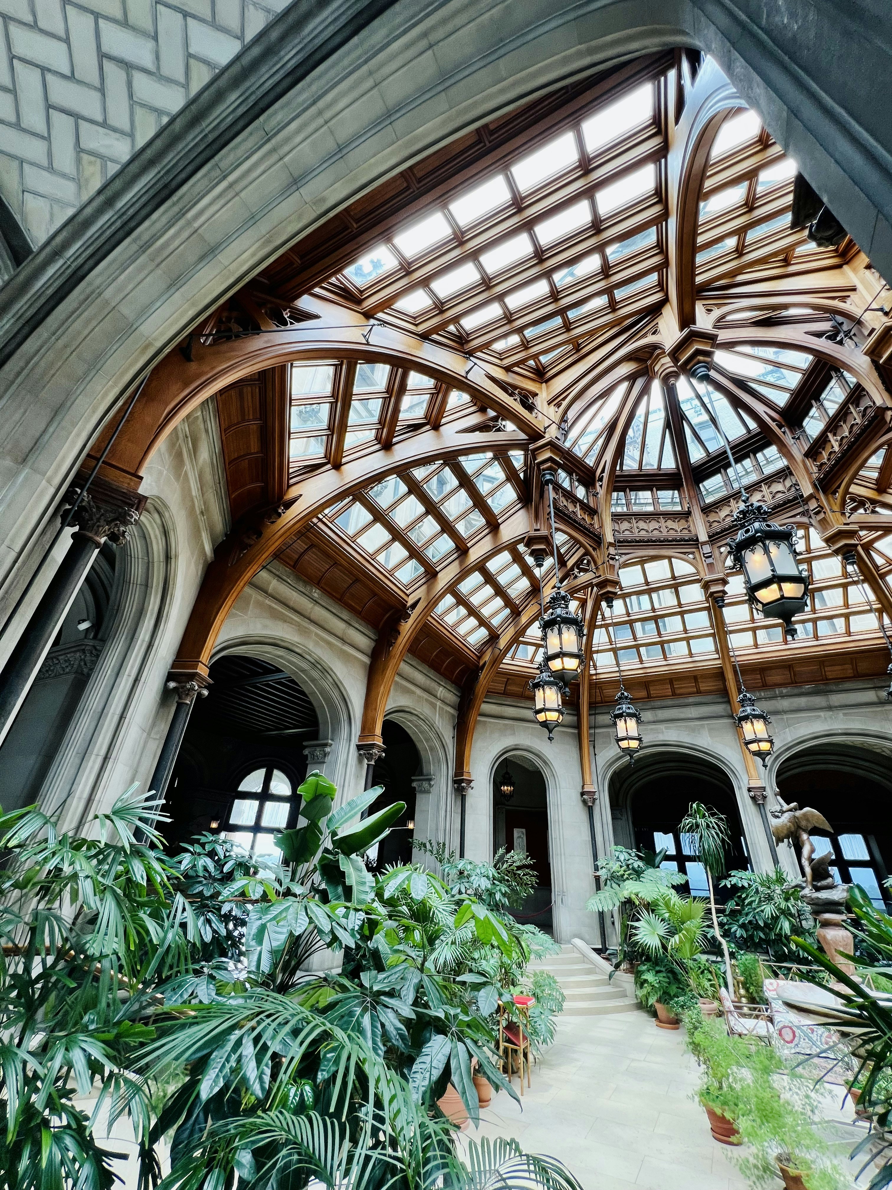 um grande edifício com um teto de vidro e muitas plantas