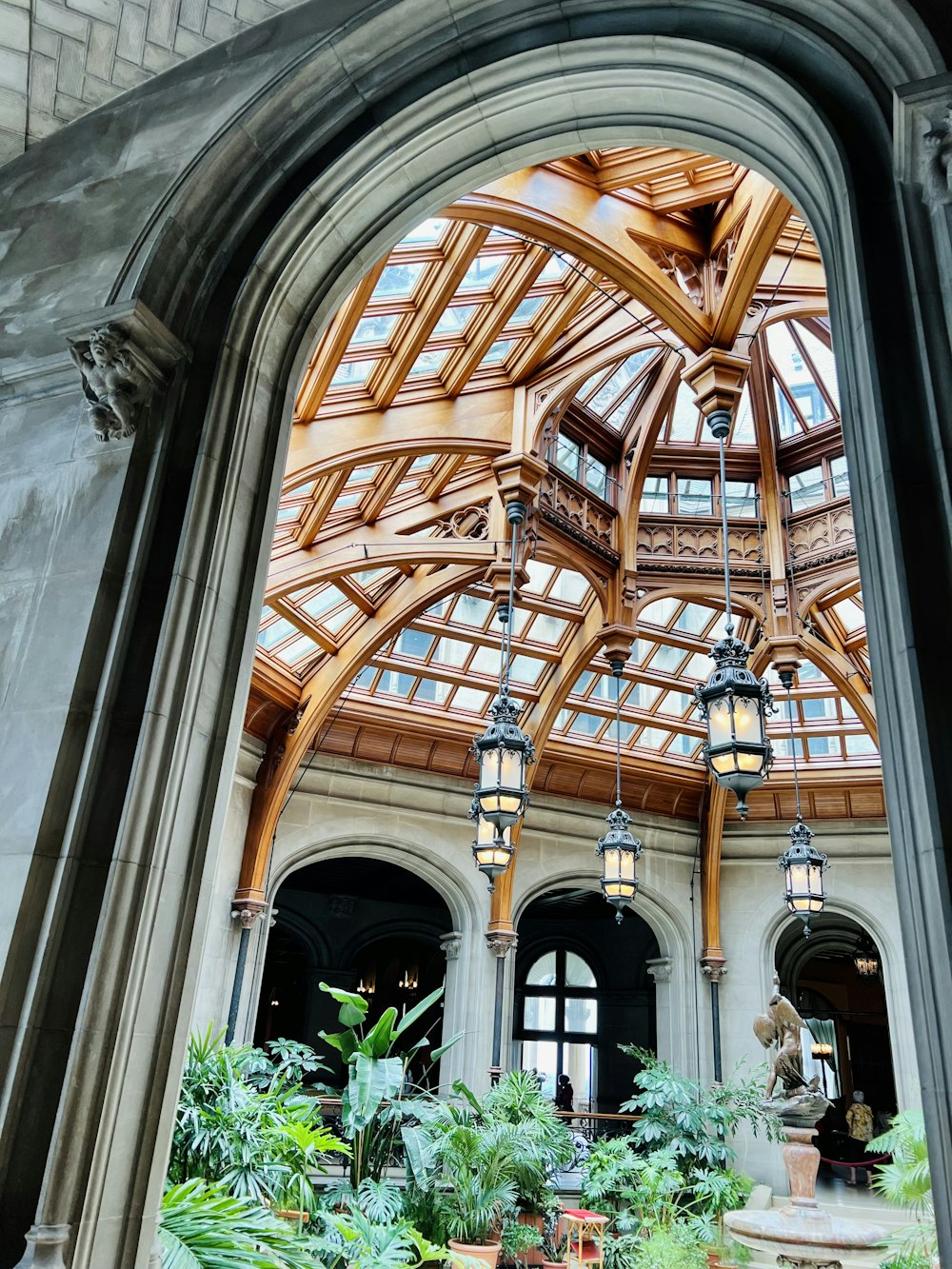 a large building with a glass roof and many potted plants