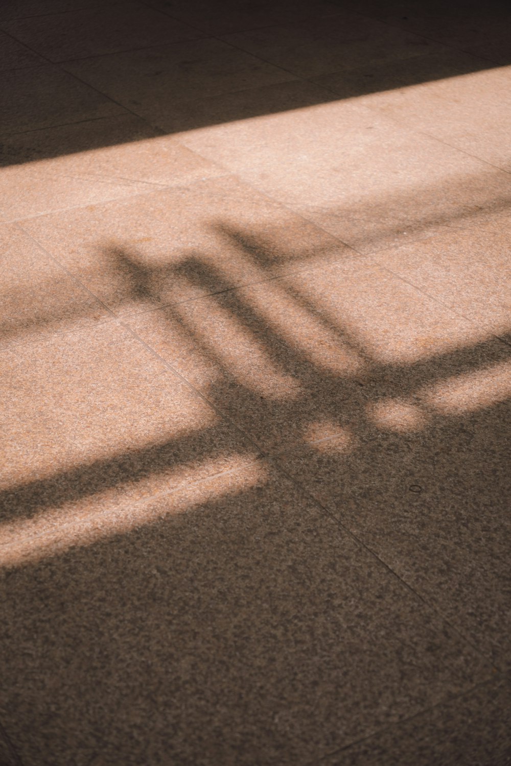 a shadow of a bench on the ground
