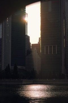 Sunset skyline of Manhattan with glowing skyscrapers reflecting in the river.
