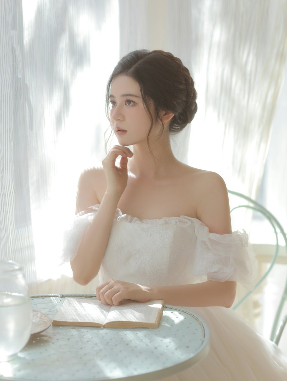 a woman sitting at a table with a book