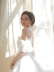 Model wearing a flowing, minimalist dress in natural light.