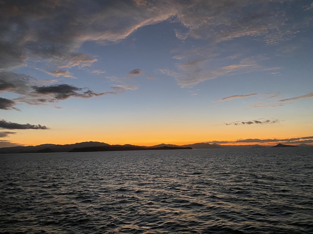 a body of water with a sky in the background