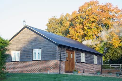 Cozy wooden cabin exterior surrounded by autumn trees in Vistalba.