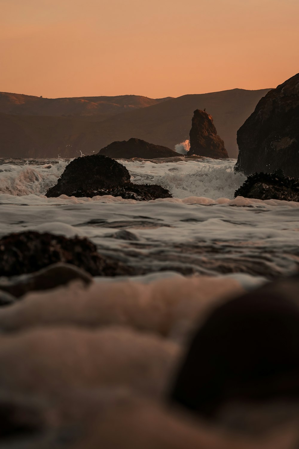 a view of the ocean with rocks in the foreground