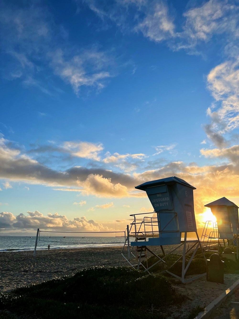 a lifeguard stand on the beach at sunset