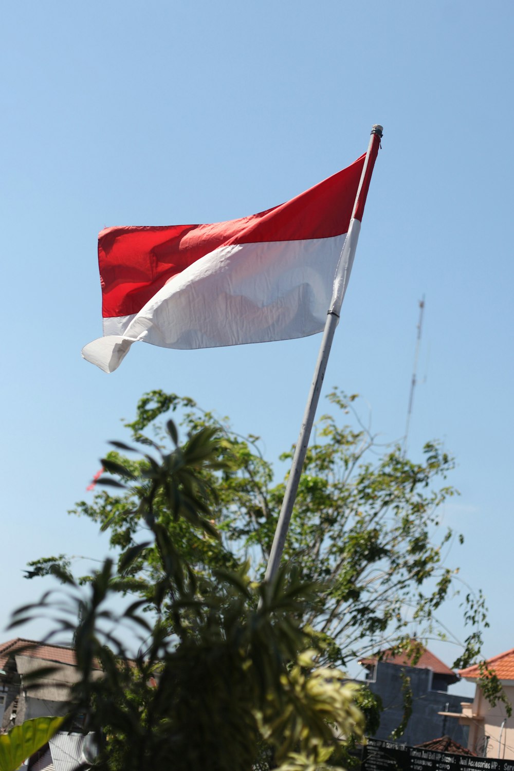 a red and white flag flying in the wind