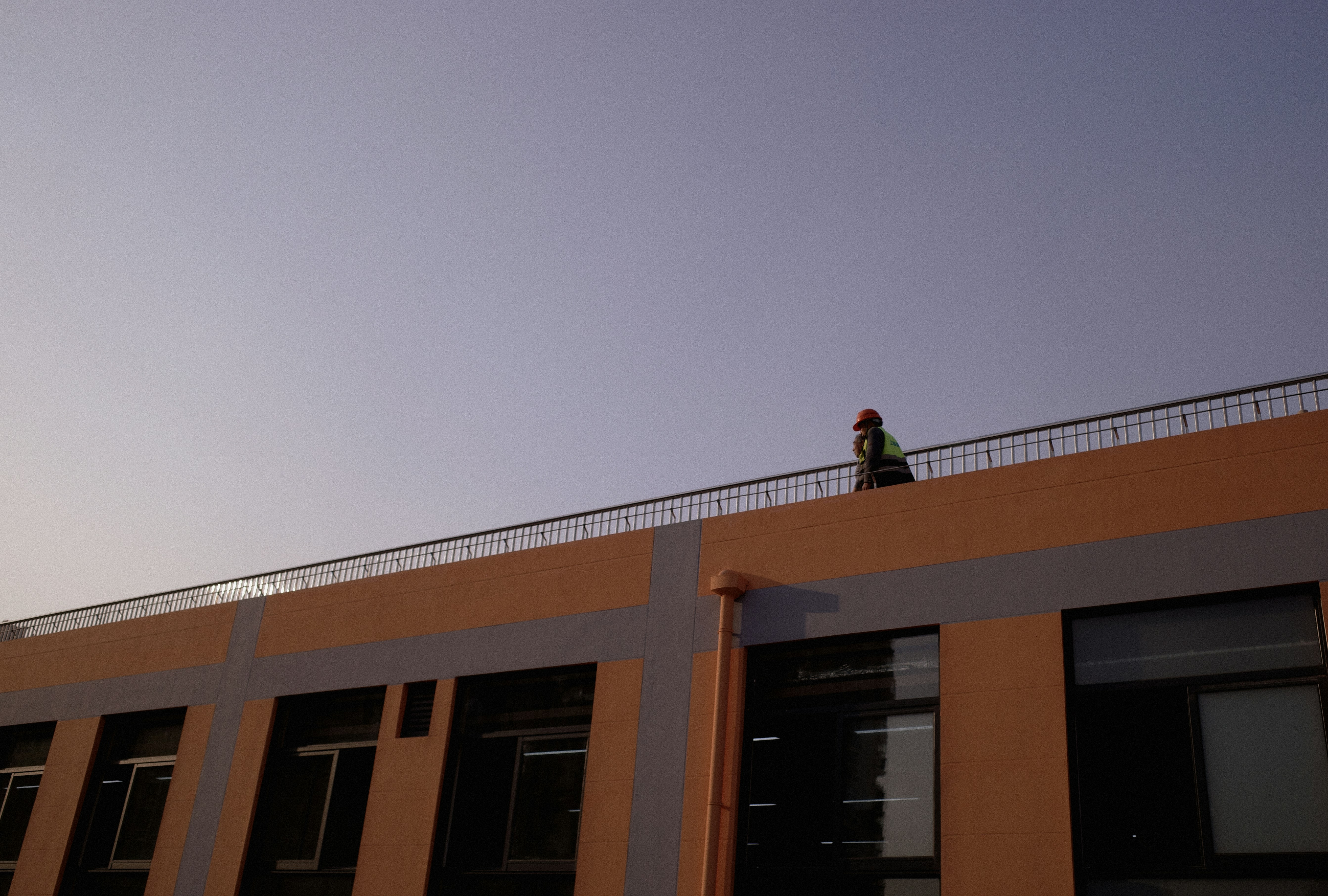 a person walking across a bridge over a building