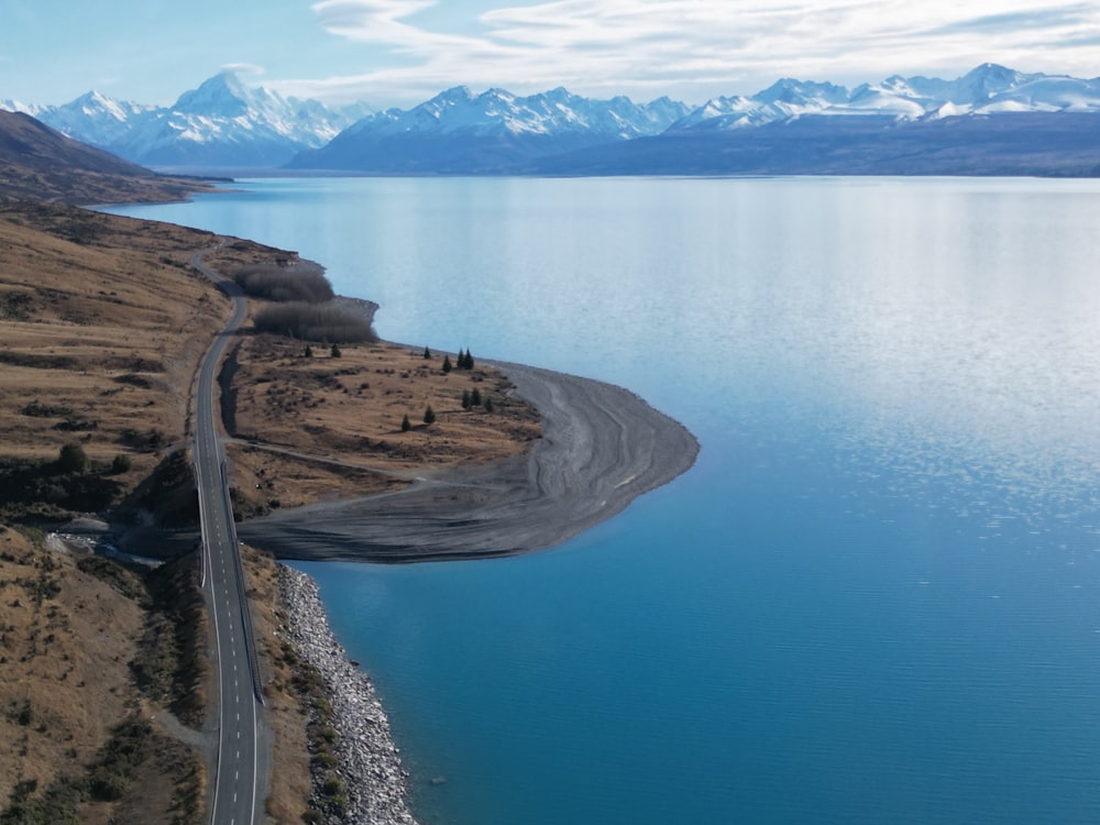 an aerial view of a road near a body of water