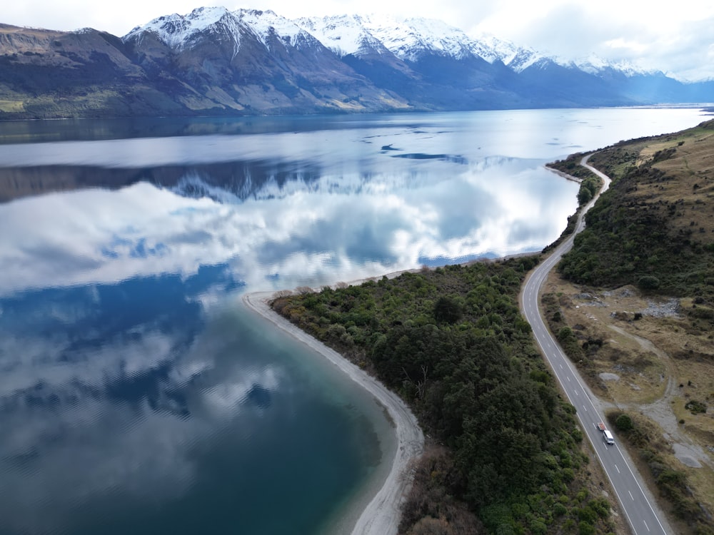 an aerial view of a road and a body of water