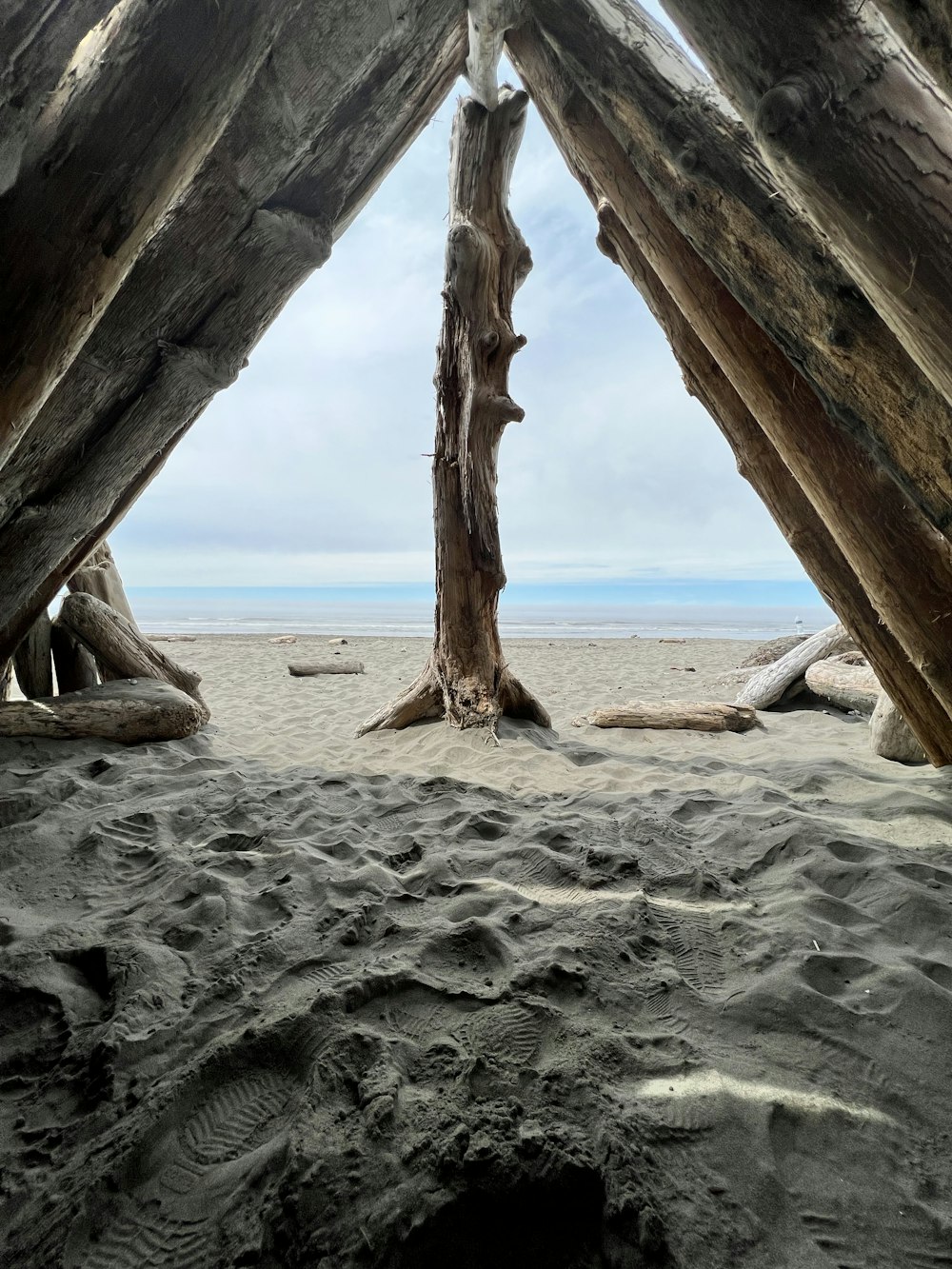 a view of a beach through a wooden structure