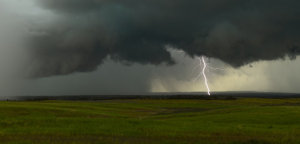 a large storm cloud with a lightning bolt in the distance