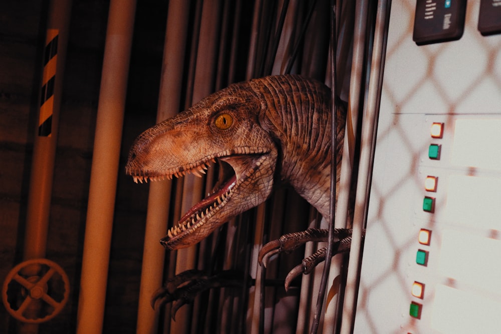 a dinosaur is in a cage with its mouth open