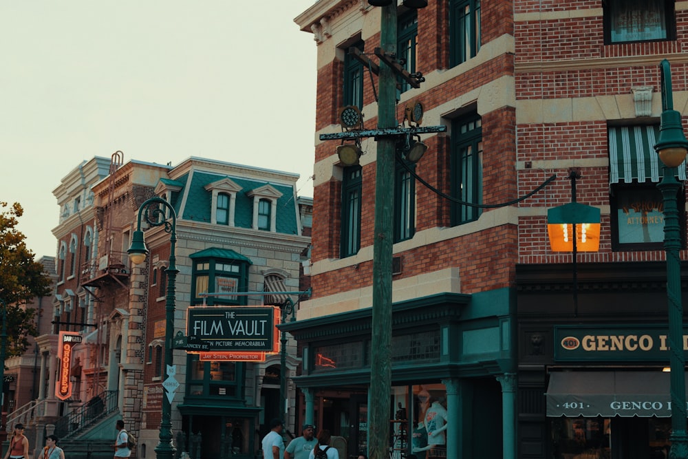 a group of people walking down a street next to tall buildings