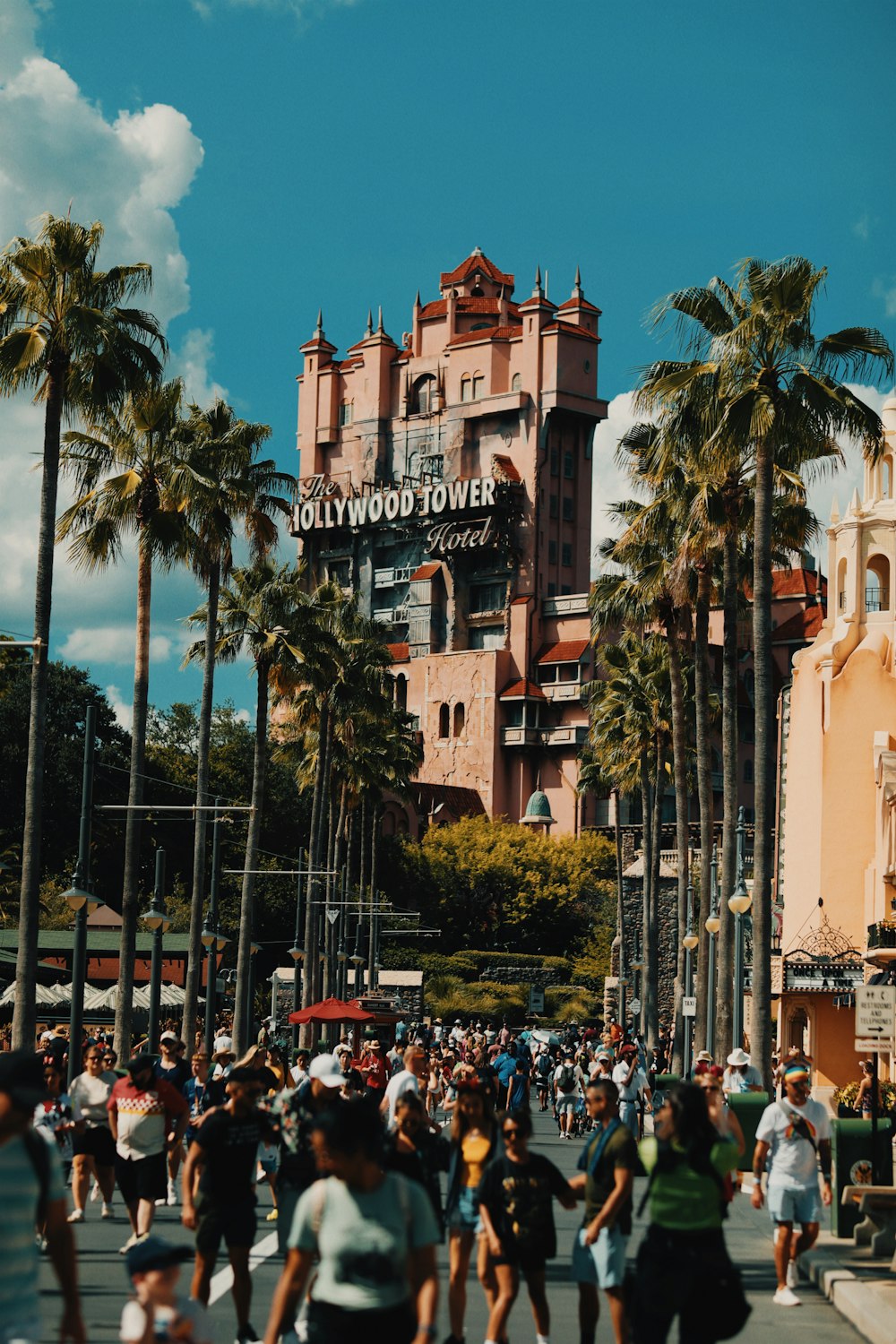 a crowd of people walking down a street next to tall buildings