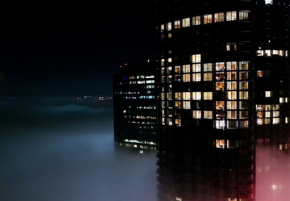 Un edificio muy alto en medio de una noche de niebla