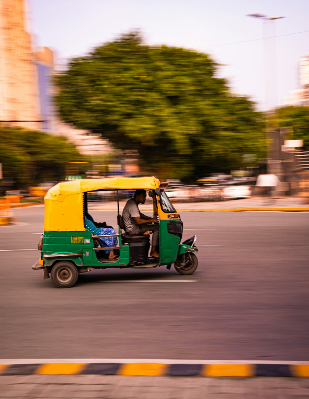 a green and yellow golf cart driving down a street