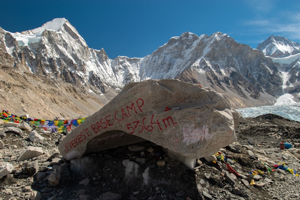 a large rock with writing on it in front of a mountain