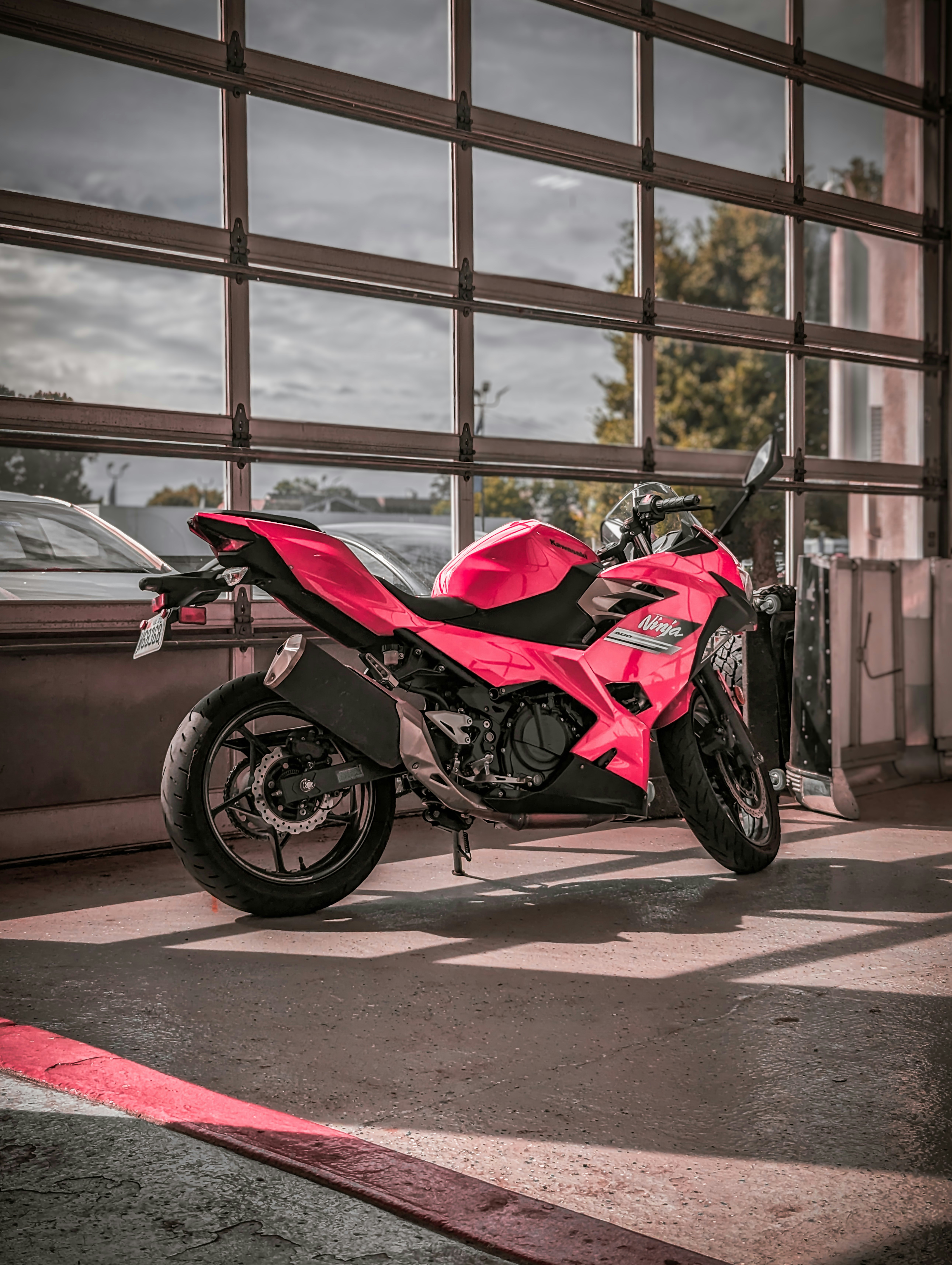 a red motorcycle parked in front of a garage