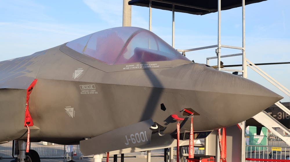 Un avión de combate sentado encima de la pista de un aeropuerto