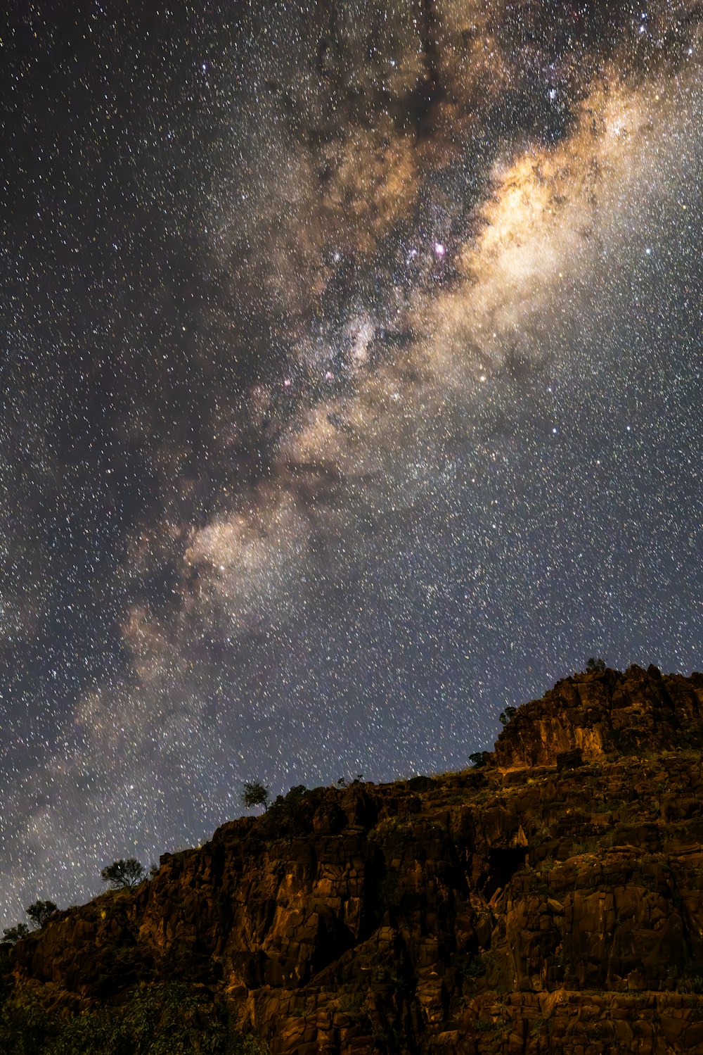 the night sky is filled with stars above a mountain