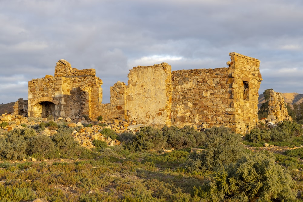 a stone building sitting on top of a lush green hillside