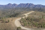 A winding dirt road cutting through the rugged landscapes around Windhoek.