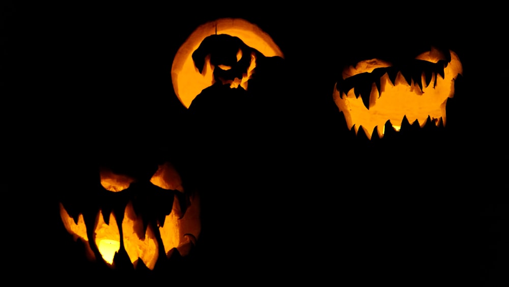 a group of carved pumpkins with scary faces