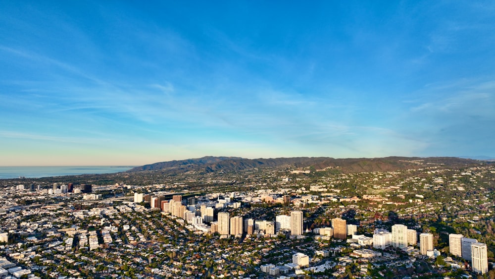 an aerial view of a city with mountains in the background