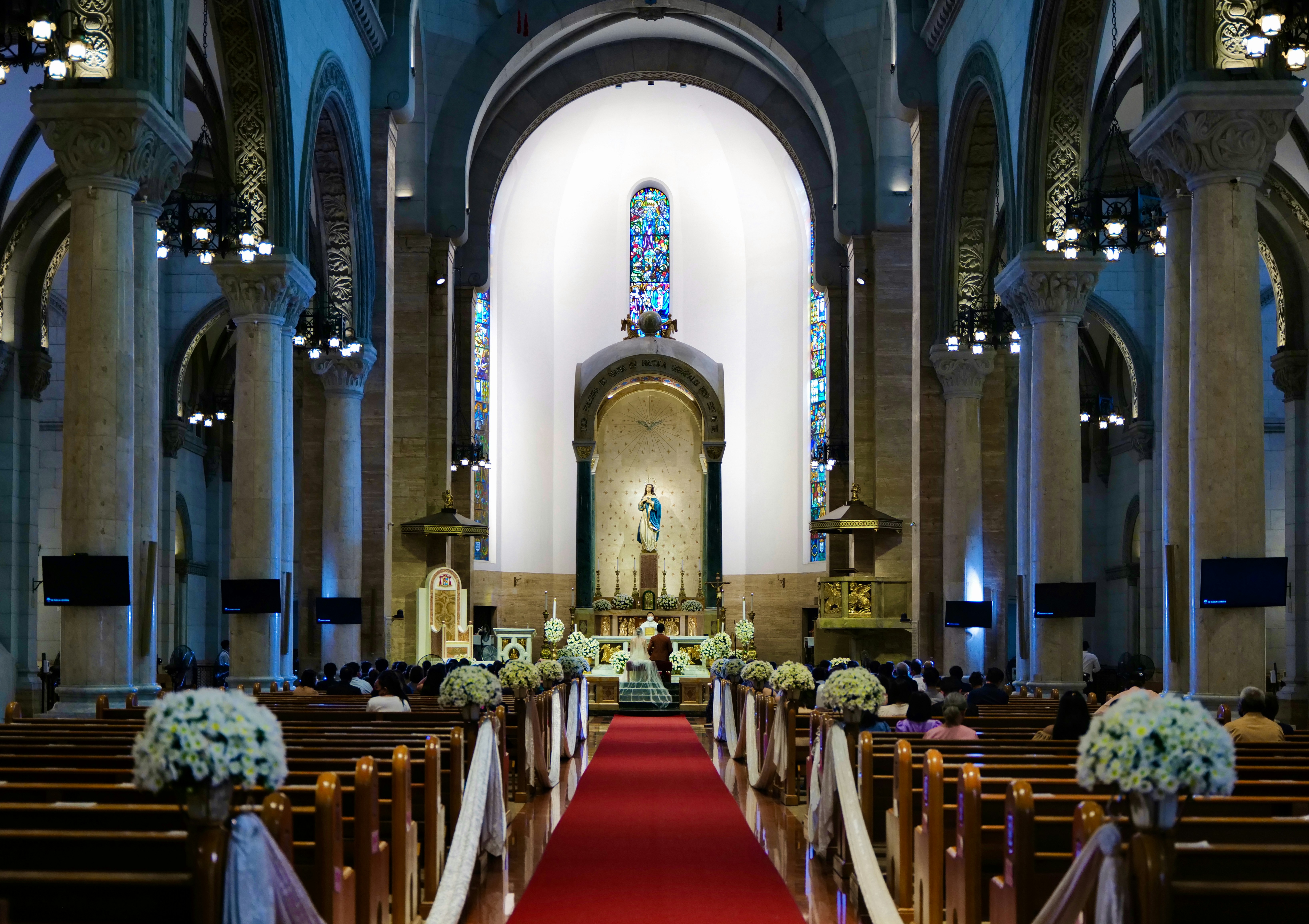 a church with a red carpet and pews