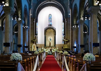 a church with a red carpet and pews
