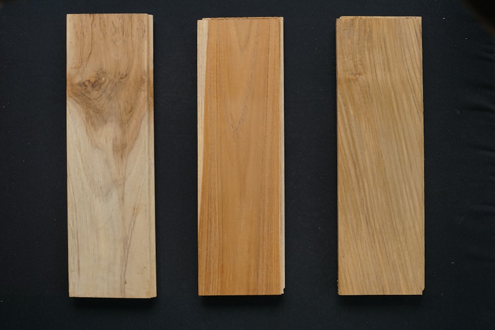 three wooden pieces of wood sitting next to each other