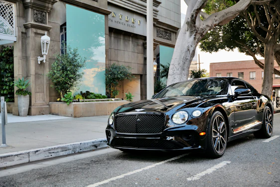 Sleek black luxury car parked in an elegant urban setting at dusk