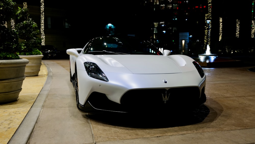 a white sports car parked in front of a building