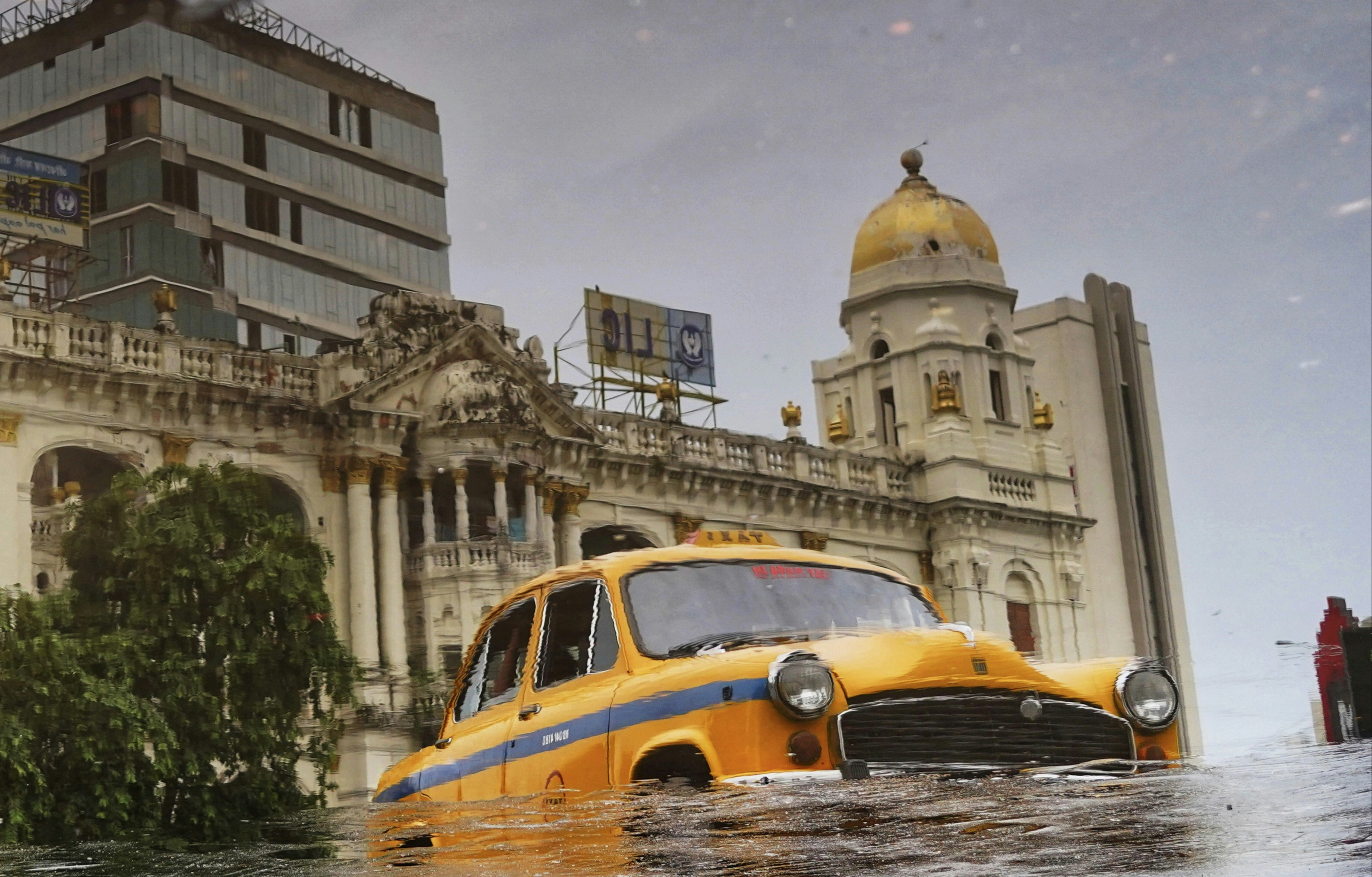 A yellow taxi driving through a flooded street photo – Free Background ...