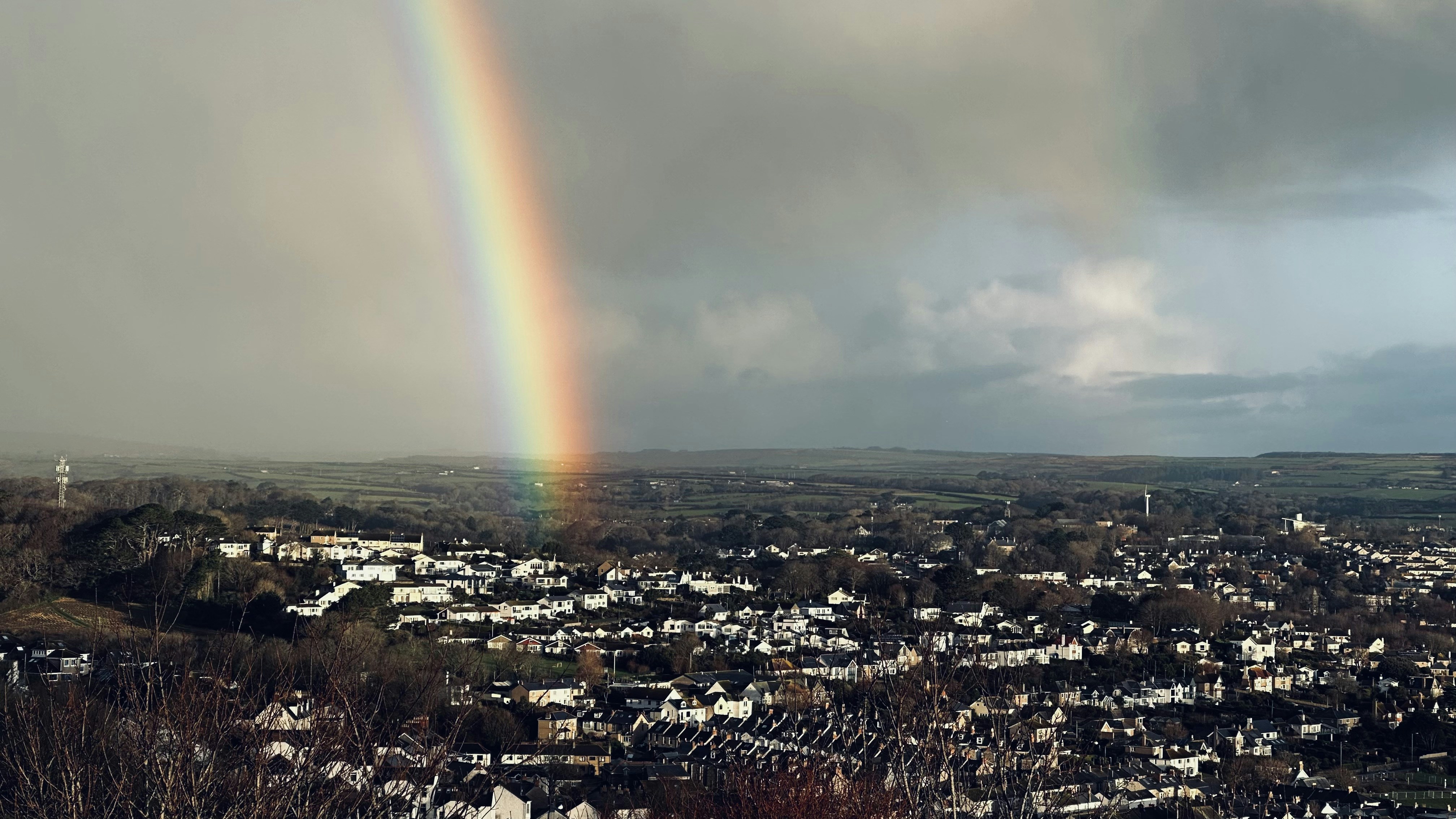 a rainbow shines in the sky over a city